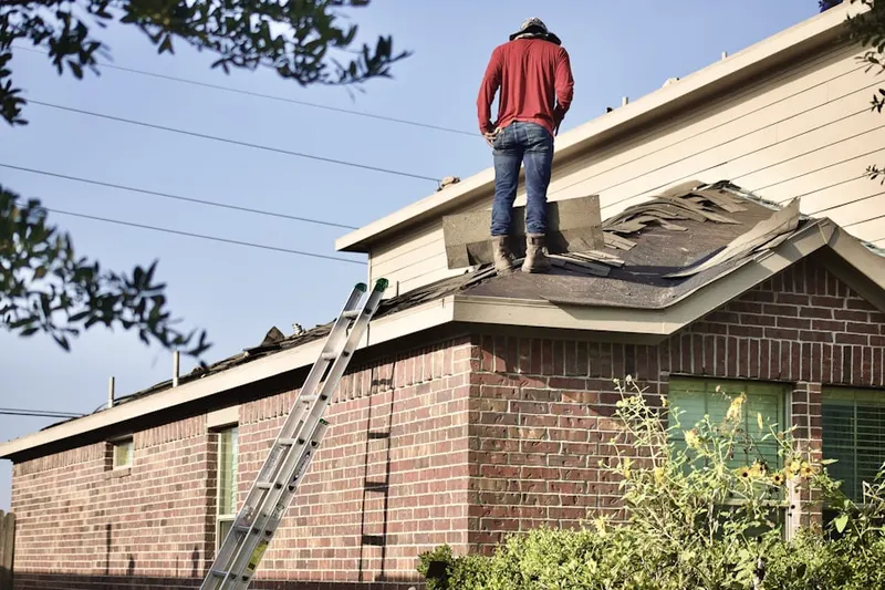 Professional roofer working on a residential roof in Hoffman Farms